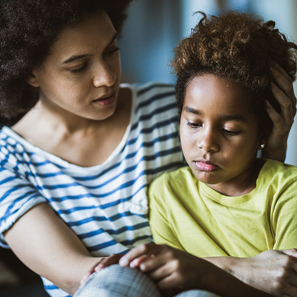 A mother comforts a young girl who is calm after a meltdown. 