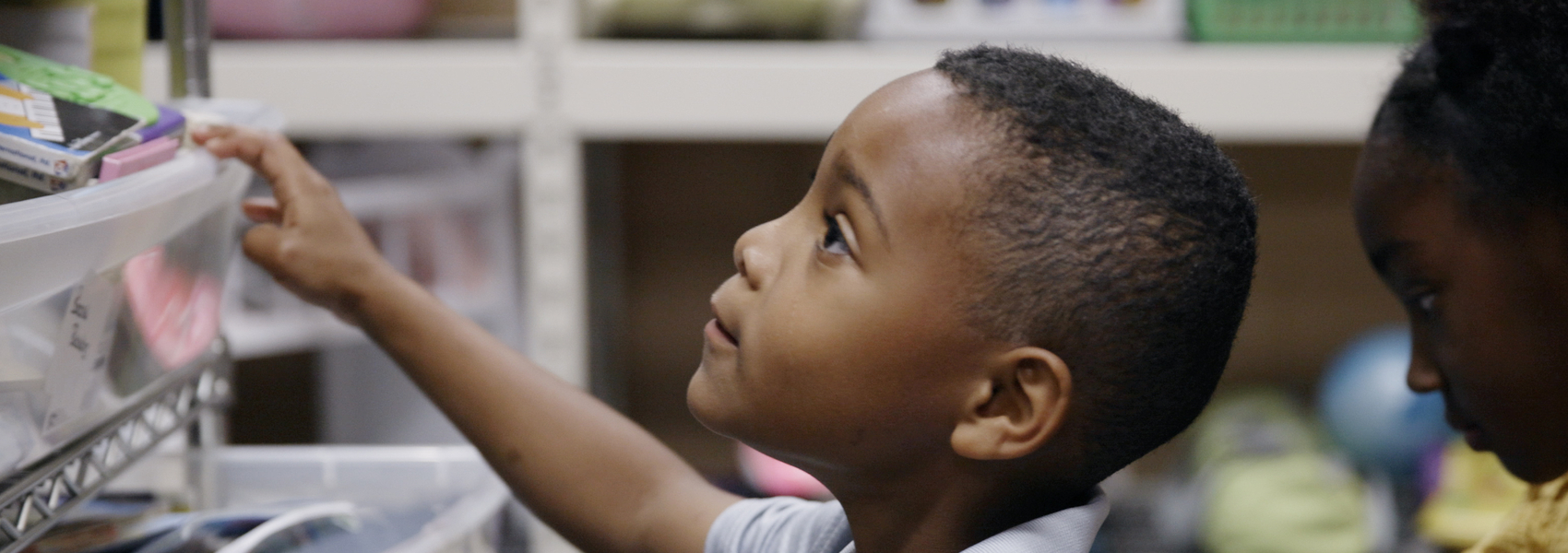 Young Black child searches the Closet of Hope for supplies