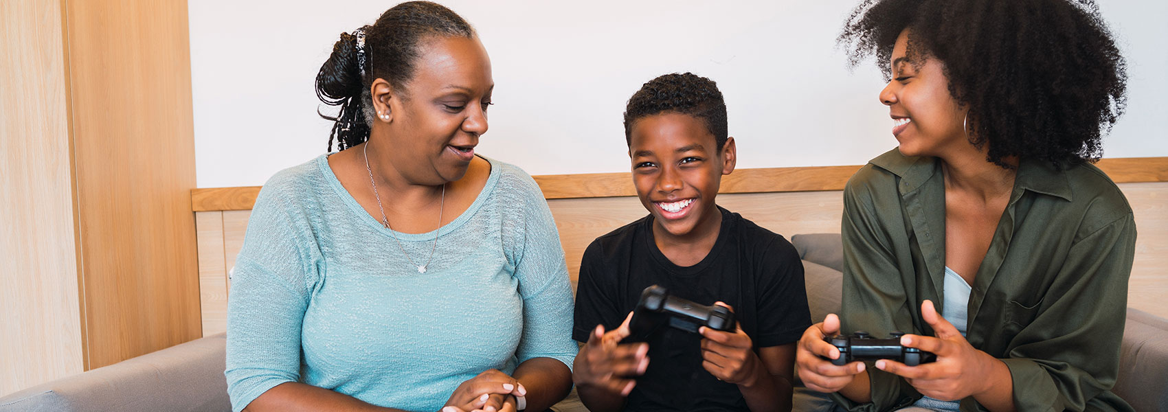 Adoptive mom with son and birth mom playing games together.