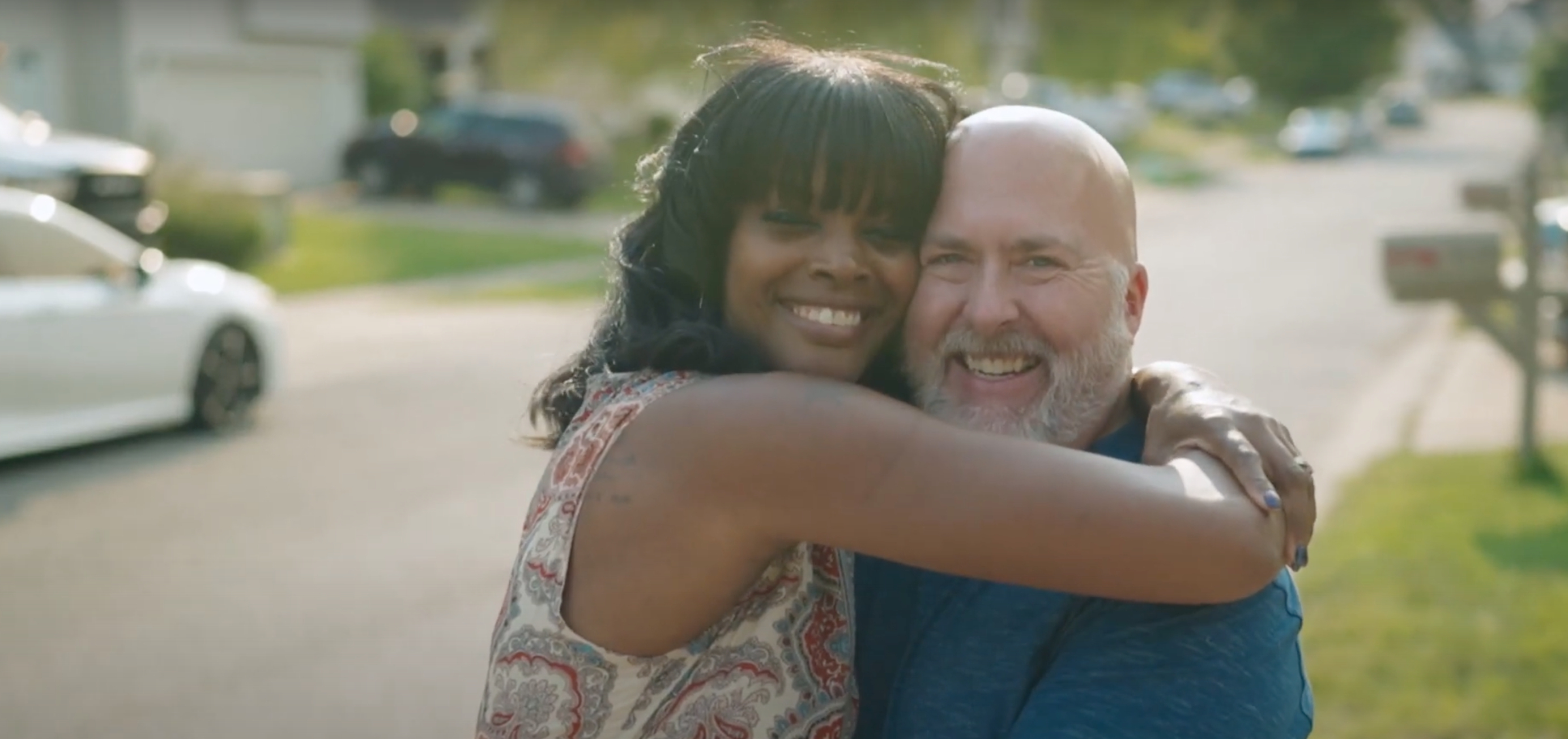 black foster mother hugs white foster father