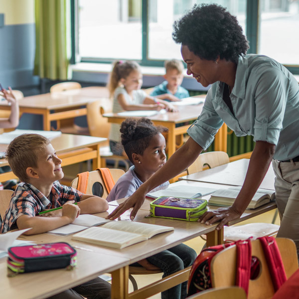A teacher talks with an elementary school student.