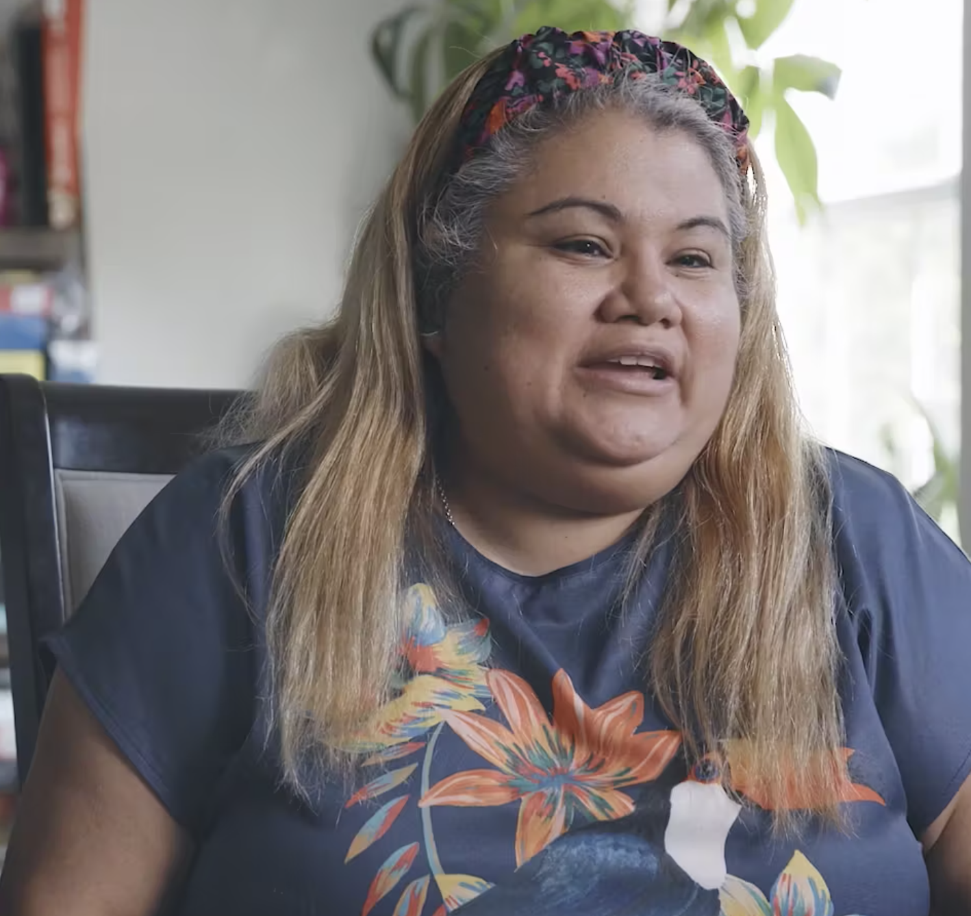 Diverse refugee foster parents sit in living room