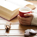 adoptive mother holds a coffee cup as she reads a book