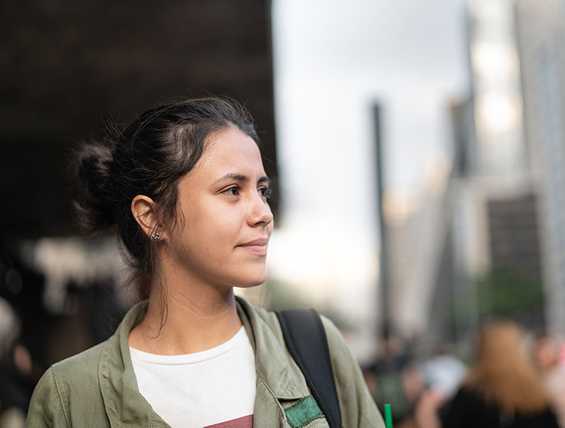 young hispanic woman walks through the city of her new home in america